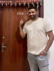 rahul parwal posing for a photo in front of his room's door indicating the room number 404