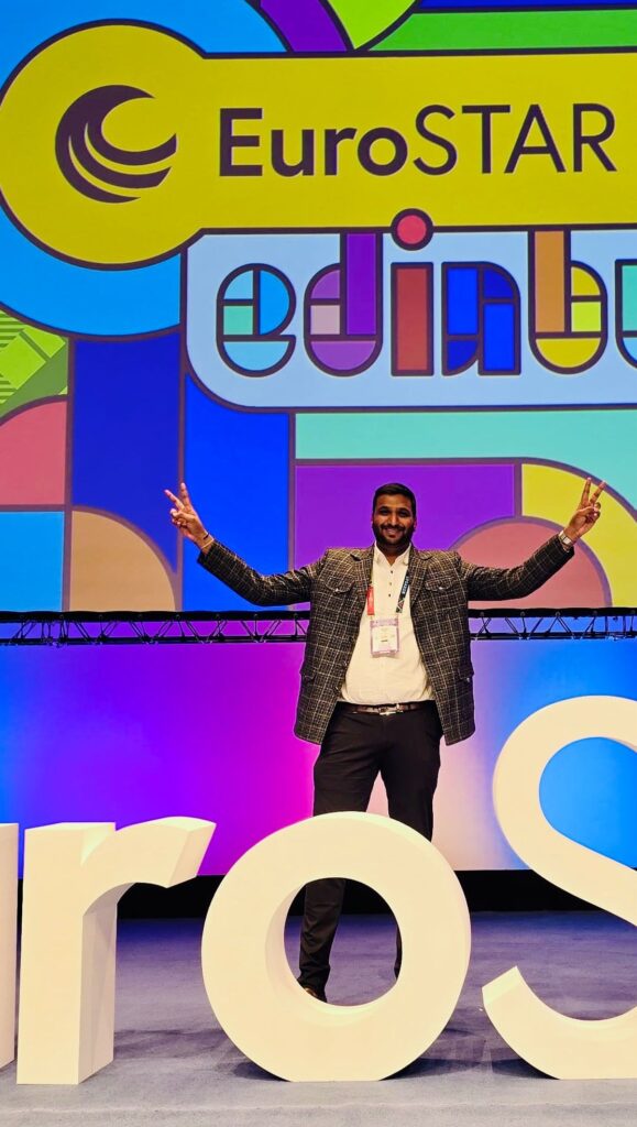 rahul parwal poses with open arms on stage at eurostar 2025 in edinburgh, standing in front of colourful event signage and large stage letters.