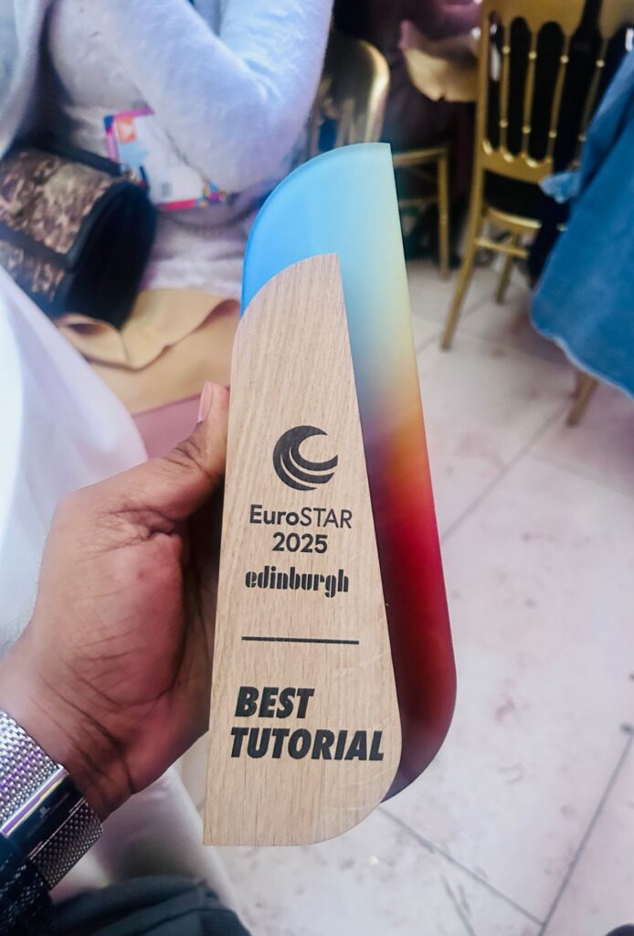 holding the EuroSTAR 2025 best tutorial award trophy with a wooden and colourful design.